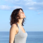 Beautiful girl breathing and smiling on the beach