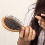 woman looking at her hair for hair loss problem