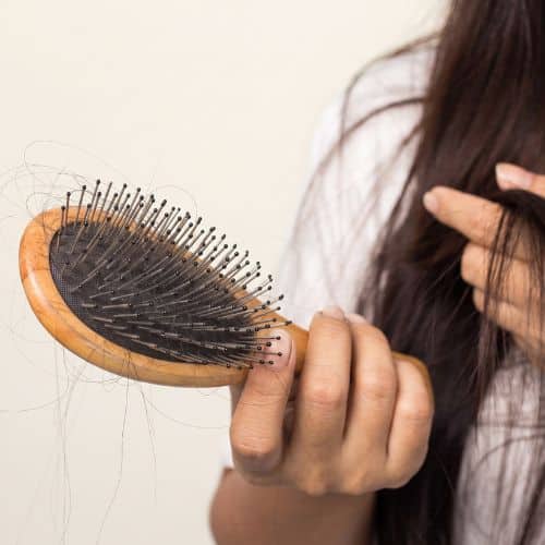 woman looking at her hair for hair loss problem