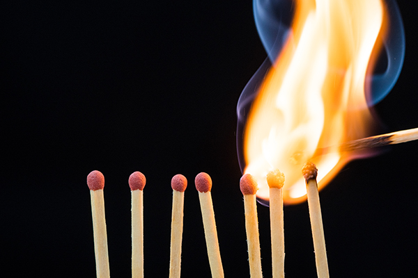 Line of burning matches on black background