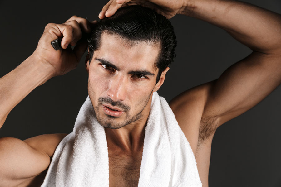 Image of a handsome young man brushing his hair