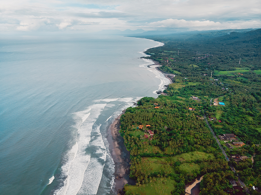 Aerial view of coastline with black sand beaches and waves